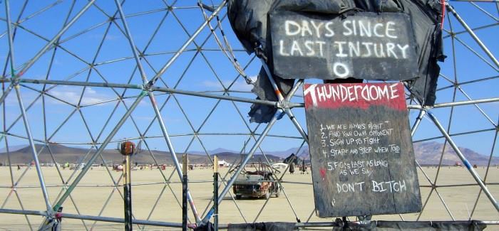 Deux tableaux à l’entrée du Thunderdome. Y sont inscrits : « Jours depuis la dernière blessure : 0 » ("Days Since Last Injury : 0") et en dessous les règles du 